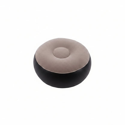 A round, low-profile pouf ottoman with a two-tone design, featuring a light taupe-beige top cushion and a black base, shown against a plain white background.
