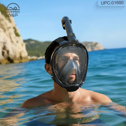 A man wearing a full-face snorkeling mask and tube, swimming in the ocean with rocky cliffs and blue sky in the background. A 'Swimming Gear' logo is visible in the top-left corner.