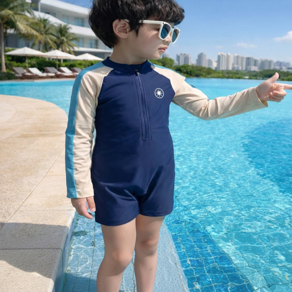 Child wearing a blue and beige swimsuit by a pool with a cityscape in the background