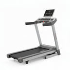 A compact folding treadmill shown in its folded position on a clean white background. The treadmill features a black running belt, gray and silver metal frame, a central control panel with buttons, and a smaller digital display screen on the front.