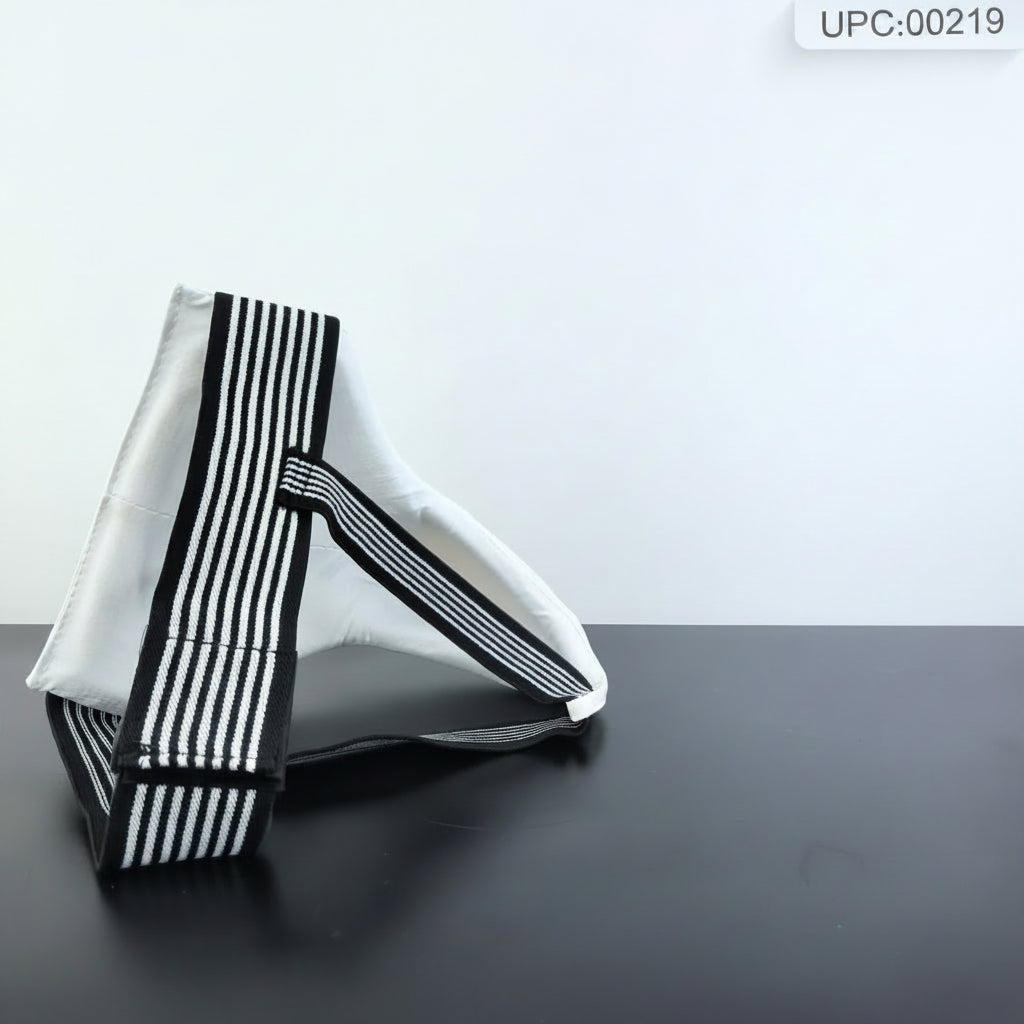 A white fabric bag with bold black and white vertical stripes on its edges, displayed on a dark surface next to a small hexagonal sign on an easel.