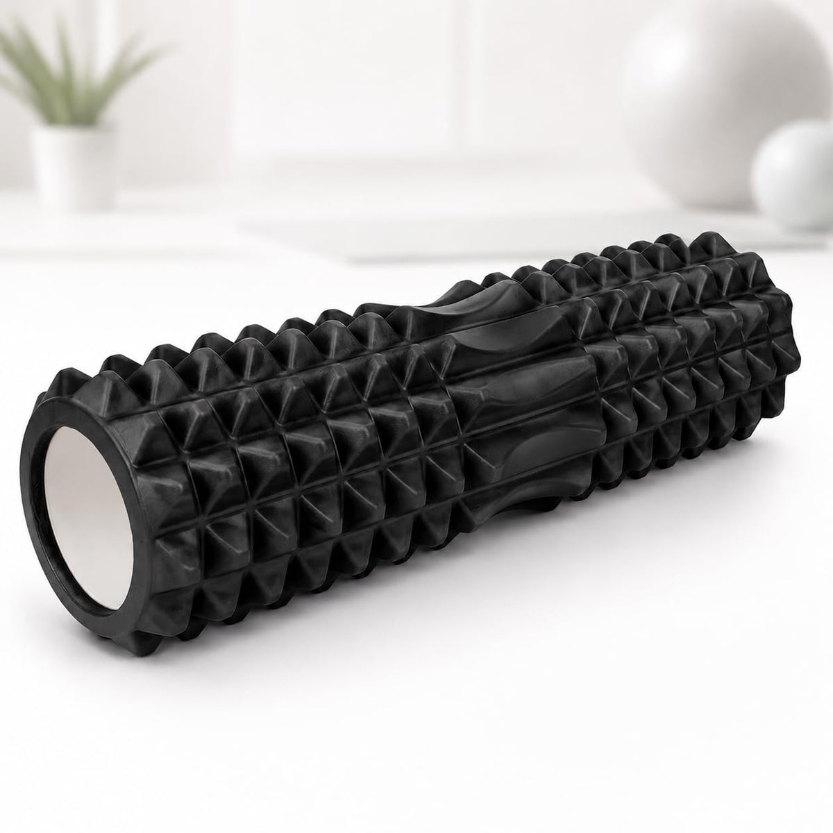 A black textured foam roller with a ribbed and pyramid-patterned surface, 