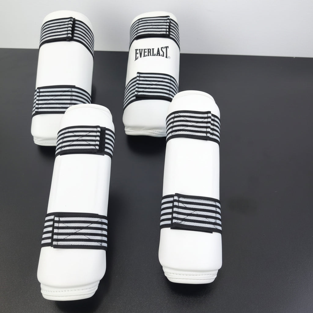 pairs of Everlast boxing shin guards displayed on a dark surface,