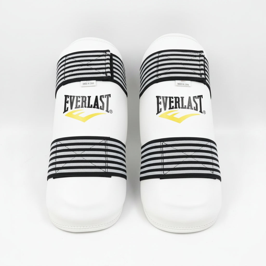 A pair of Everlast boxing shin guards in white with black and white striped elastic