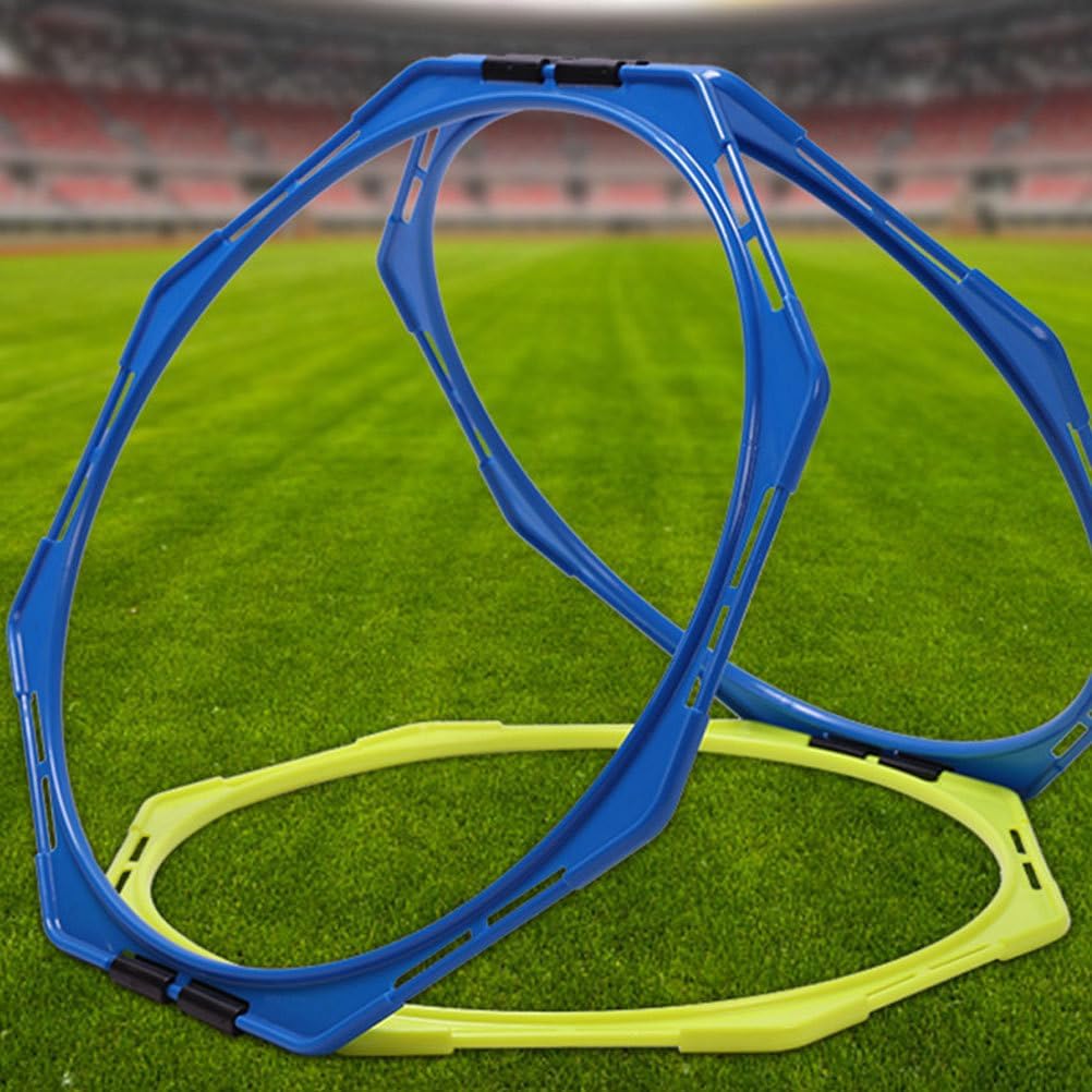 Blue and yellow plastic agility rings on a green soccer field with a blurred stadium background.