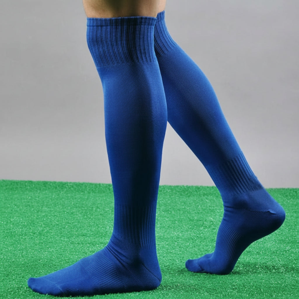 Blue knee-high socks on a person standing on green grass 