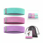 Set of resistance bands in green, pink, and purple with a drawstring bag on a white background.