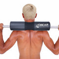 Man holding a barbell with a black and gray BEAR weightlifting accessory on a white background