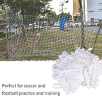 Soccer goal net with additional netting on a grassy area with cars and trees in the background.